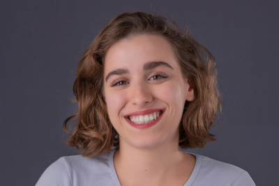 Portrait of a young woman with curly hair smiling confidently