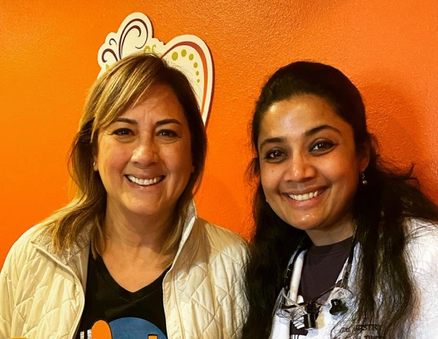 Dr. Radhika Srikrishnan Iyer posing with a smiling patient at Dental Artistry Irving