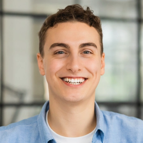 Portrait of a smiling young man in a blue shirt outdoors