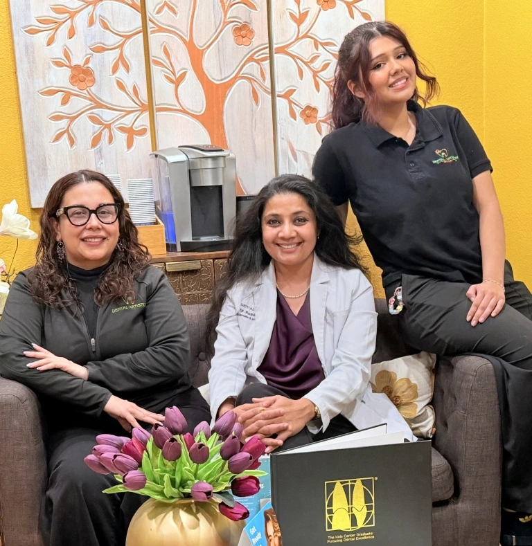Dr. Radhika Srikrishnan Iyer and two Dental Artistry Irving staff members posing together in the office waiting room
