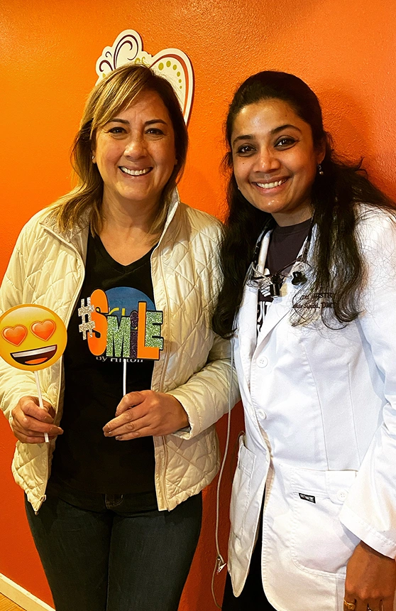Dr. Radhika Srikrishnan Iyer posing with a smiling patient at Dental Artistry Irving